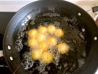 香炸红薯丸子,锅中添油，油七八分热的时候就可以下锅了，，太热的油会使红薯丸子表面糊了，里面还没有熟，所以要中小火慢炸。