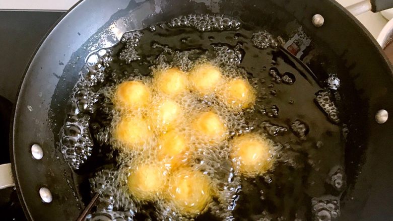 香炸红薯丸子,锅中添油，油七八分热的时候就可以下锅了，，太热的油会使红薯丸子表面糊了，里面还没有熟，所以要中小火慢炸。