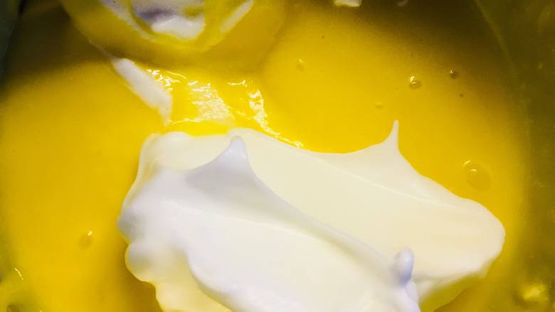 新春“福气”奶油卷,取三分之一蛋白加入蛋黄糊中。翻拌均匀