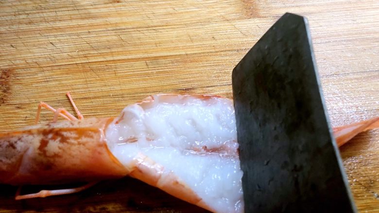 蒜蓉芝士焗阿根廷红虾,再用刀轻轻剁几下，这一步为的是烤的时候虾肉不会缩在一起
