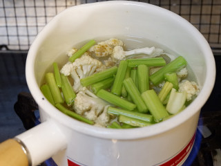 肥牛麻辣香锅,锅中烧开水，加入西芹和菜花焯水。焯好沥干水备用。