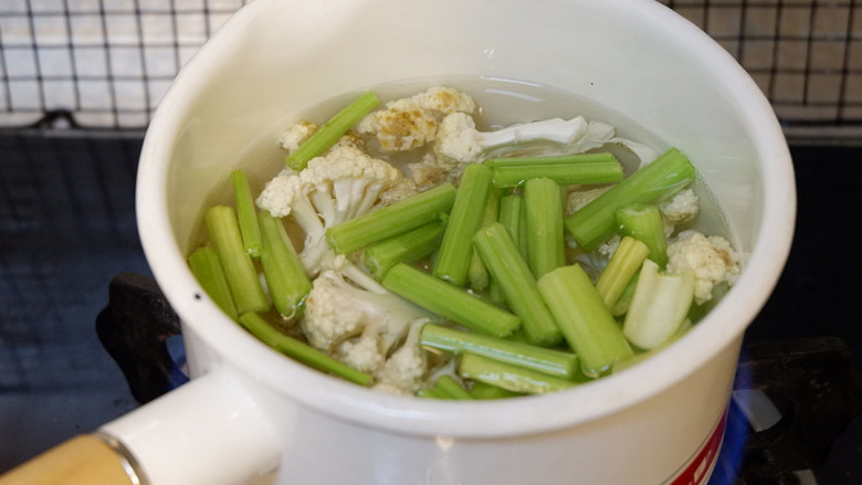 肥牛麻辣香锅,锅中烧开水，加入西芹和菜花焯水。焯好沥干水备用。