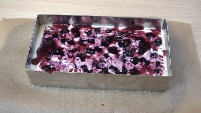 蓝莓芝士慕斯蛋糕,凝固好的慕斯上铺一层蓝莓果酱（保留少许果汁，最后做装饰用）