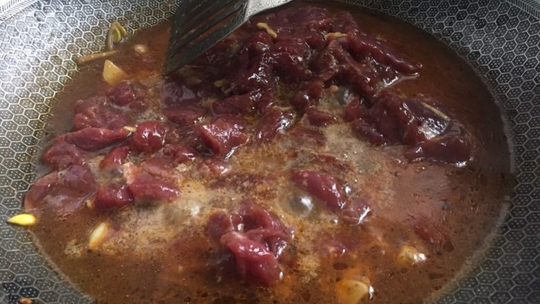 麻辣水煮牛肉片,把牛肉片少量多次放入红汤中烫熟捞出
