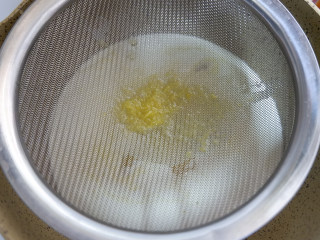 香橙奶冻,离火，加入沥干的吉利丁片，搅拌均匀。用筛网过筛一遍。