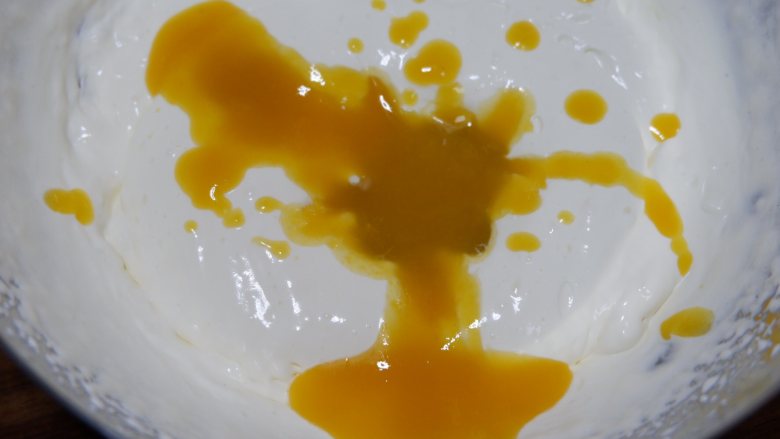 芒果慕斯杯,将放凉的芒果泥倒入淡奶油中搅拌均匀
