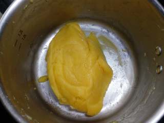 南瓜奶黄包,17. 搅拌至能略成形，关火把容器离开锅。 