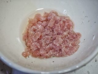 瘦肉杂蔬麦麸粥,把肉丁放进小碗里，放点料酒和胡椒拌匀祛除腥味。
