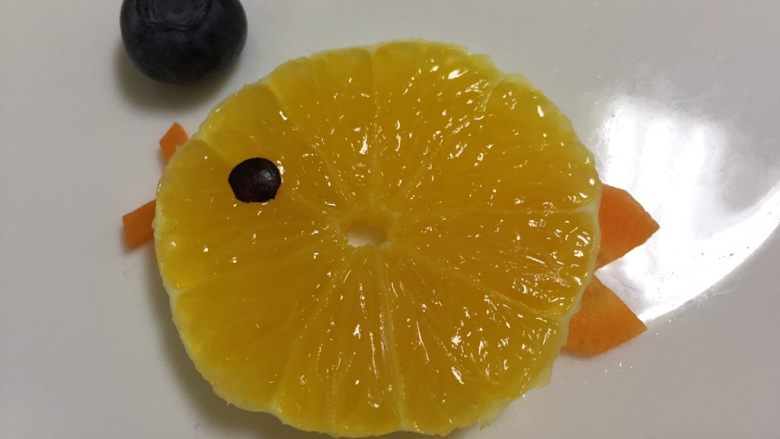 橙子小鱼,把胡萝卜的嘴巴和尾巴压在橙子下面，蓝莓就是小鱼吐的泡泡，如图摆盘