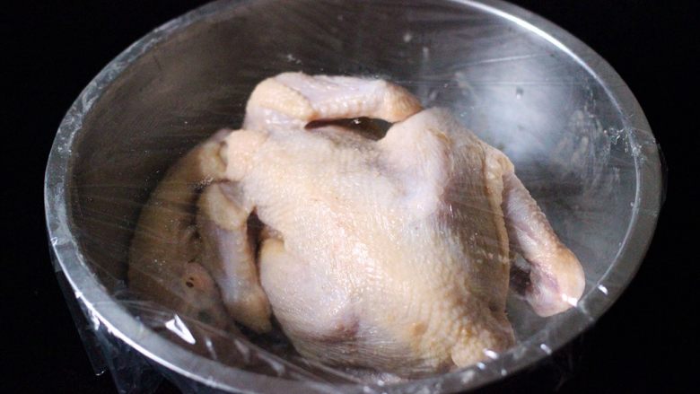 盐焗鸡,涂抹好的鸡放入盆中、打上保鲜膜后、放入冰箱冷藏腌制过夜