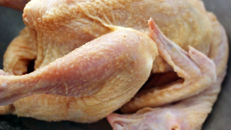 盐焗鸡,把盐焗鸡粉均匀地涂抹在鸡的各个部位