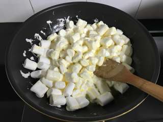 花生牛轧糖,放入棉花糖翻拌一下让棉花糖沾上黄油。