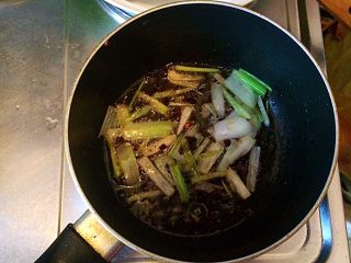土豆牛肉丸子烩饭,将煎丸子锅里的油倒出一部分，留适量的油，放入切好的大葱。
