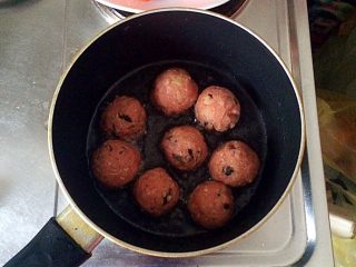 土豆牛肉丸子烩饭,不粘锅中倒适量的油（大概没过丸子的三分之一即可），将丸子放入锅中，开始煎。