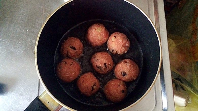 土豆牛肉丸子烩饭,不粘锅中倒适量的油（大概没过丸子的三分之一即可），将丸子放入锅中，开始煎。