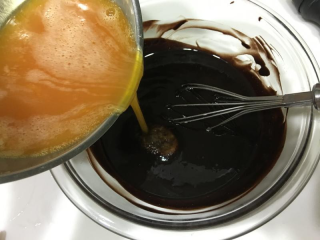 巧克力熔岩蛋糕,蛋液慢慢加入巧克力糊搅拌均匀。