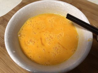 青椒炒蛋,加几滴料酒可以去腥气，用筷子搅拌打散。