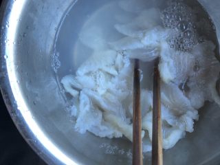水煮龙利鱼,煮菜的过程中，在腌鱼片的碗中倒入沸水，用筷子剥散鱼片，沥去混浊的水。这一步可以避免在煮鱼片时出现过多浮末。