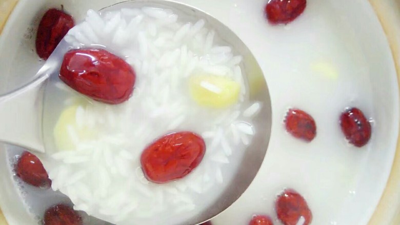 春节健康菜:暖身滋补糯米粥,加入红枣生姜后搅拌一下