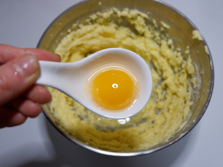 咸香芝士曲奇饼干,加入蛋黄，用打蛋器打发至蓬松发白的状态。