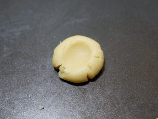 咸香芝士曲奇饼干,用拇指在中心处按压下去，像图片中这样。