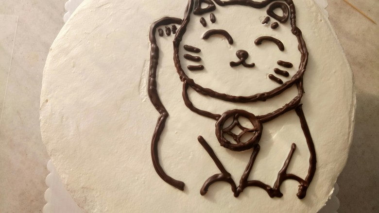 招财猫蛋糕,把凝固好的巧克力招财猫取下来放在蛋糕上。