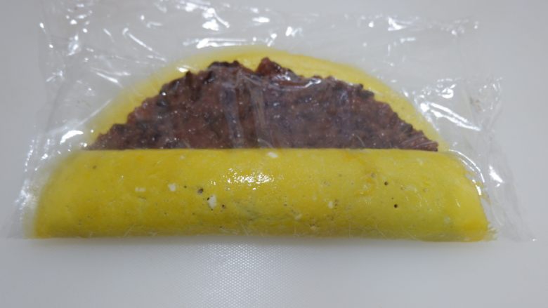 赤豆糯米蛋卷,用保鲜膜协助卷起来。
