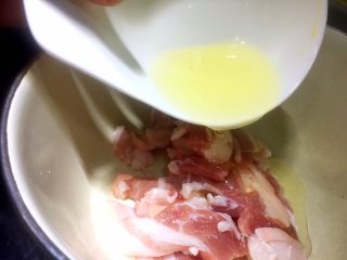 川味粉蒸肉,将一大勺色拉油和一小勺料酒倒入肉片中和匀，让肉片表面裹上油