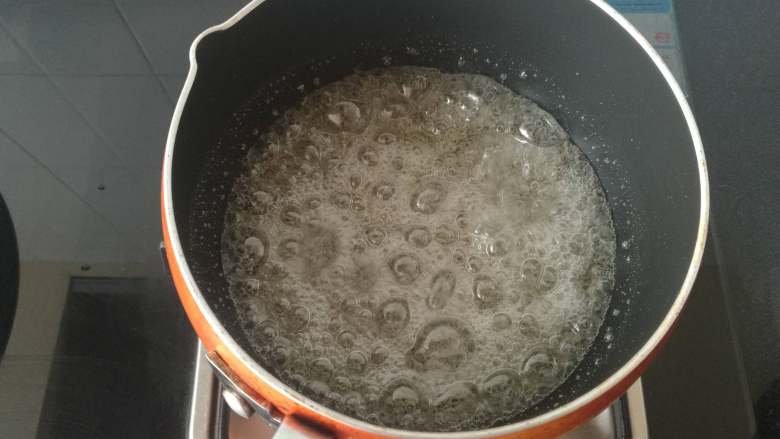 焦糖海盐玛德琳,先制作海盐焦糖酱：150克细砂糖加入50克水，中小火加热，期间不用搅拌（煮糖的锅要深一点）。同时将淡奶油倒入另一个锅里加热至沸腾