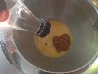 焦糖海盐玛德琳,鸡蛋打散，加入焦糖酱和水饴拌匀（水饴可用蜂蜜代替，焦糖酱保持可流动状态更容易拌匀）
