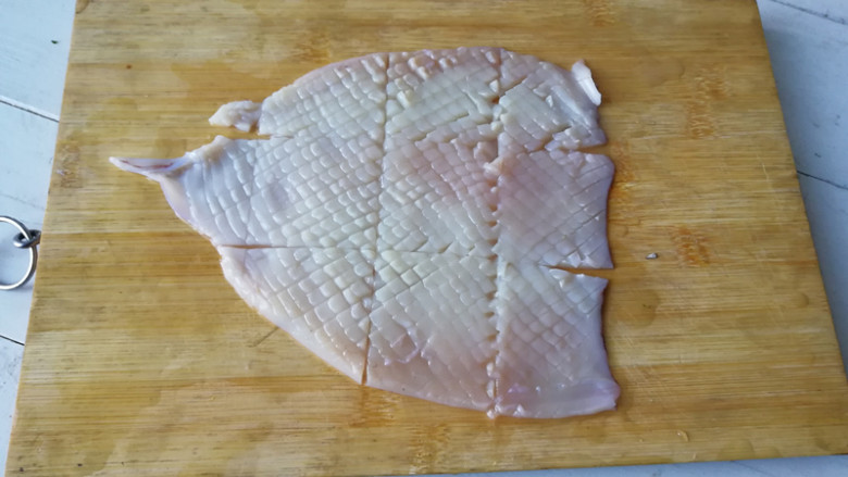 【海鲜沙拉】,将鱿鱼用刀划开，在鱿鱼的里侧切十字花刀，在切成块，如果不会切十字花刀，直接切成条也可以，切花刀是为了美观一些