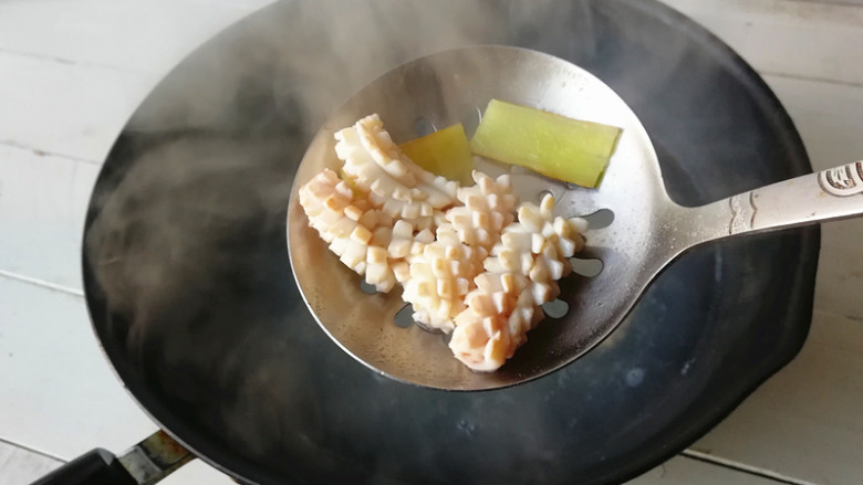 【海鲜沙拉】,水烧开，下入鱿鱼块，煮至鱿鱼卷起
