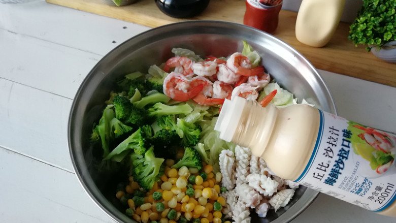 【海鲜沙拉】,将西兰花、西生菜、玉米粒、青豆、大虾、鱿鱼放在盆内，加入海鲜沙拉汁