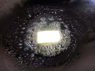 #春节健康菜# 铁板黑胡椒牛肉粒,锅热后放入黄油。