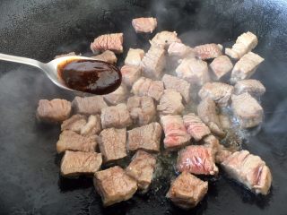 #春节健康菜# 铁板黑胡椒牛肉粒,放入1勺的黑胡椒酱汁和少许的盐。