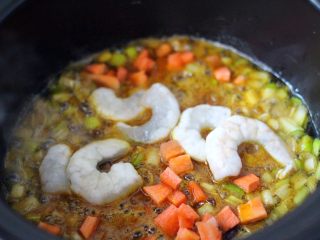 什锦咖喱虾仁蛋炒饭（砂锅版）,加入洗净的虾仁和胡萝卜丁后、小火继续翻炒片刻