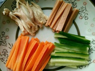 炸春卷(饺子皮版),把胡萝卜、火腿肠、黄瓜和鸡腿切成条。