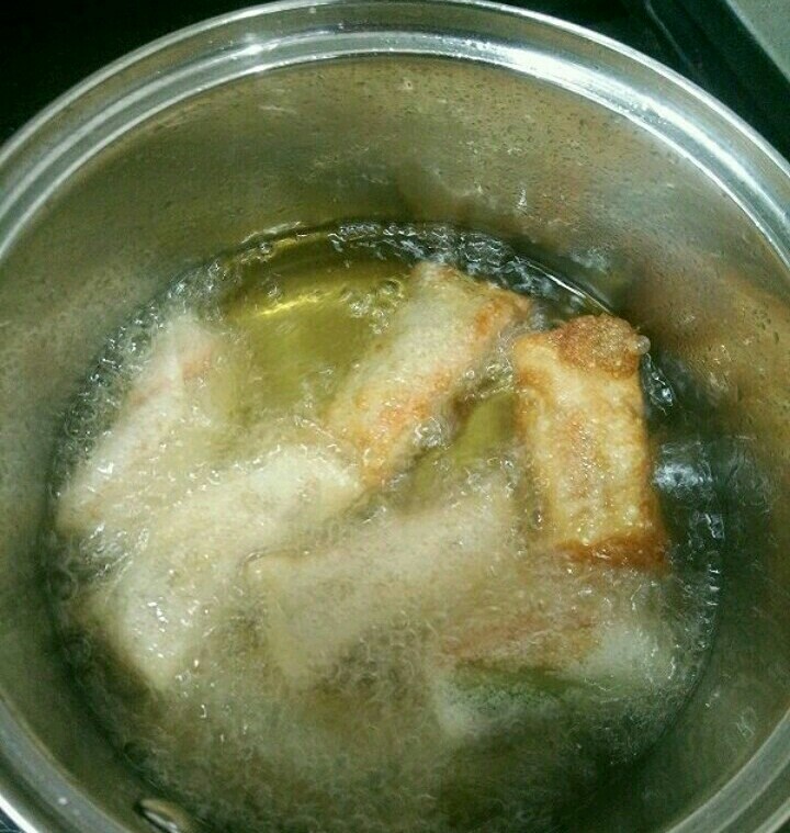 炸春卷(饺子皮版),用个小锅放适量油，待油温八成热时下春卷，炸至金黄即可出锅。