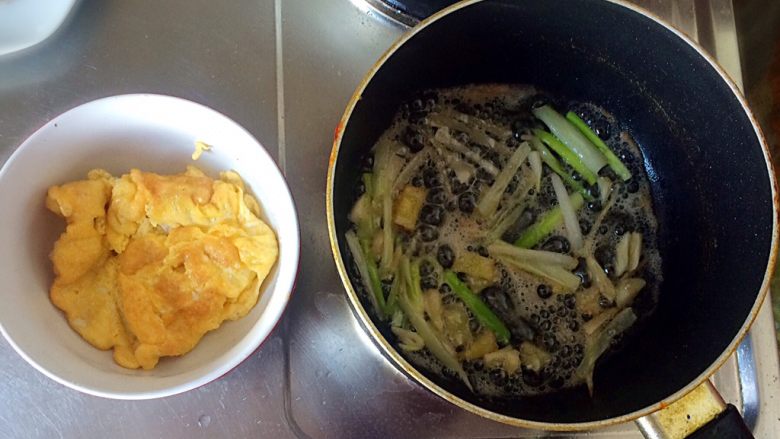 梅干菜炒意面,待鸡蛋两面金黄时，出锅。并倒入葱、姜、蒜。