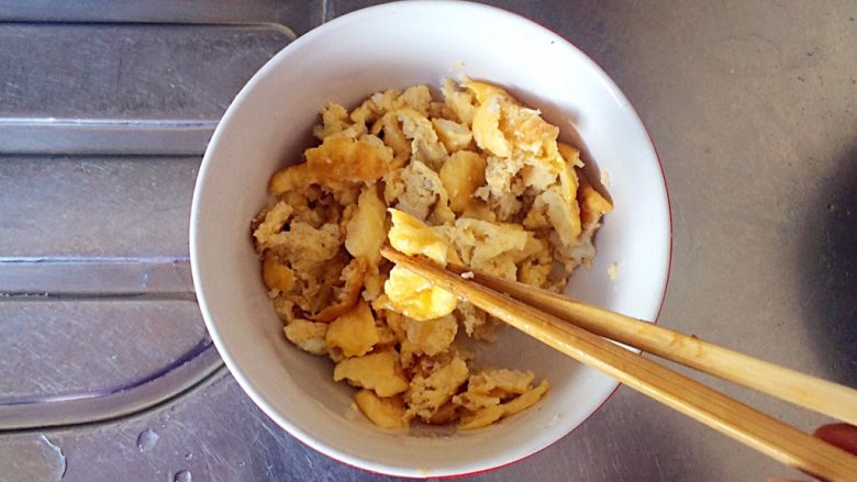 梅干菜炒意面,将鸡蛋用筷子夹成小碎块。
