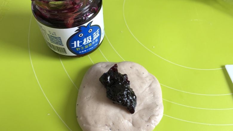 蓝莓夹馅小餐包（一次发酵法）,取面团揉圆按扁，包入一小勺蓝莓酱，不要包太多噢，不然不容易收口捏紧