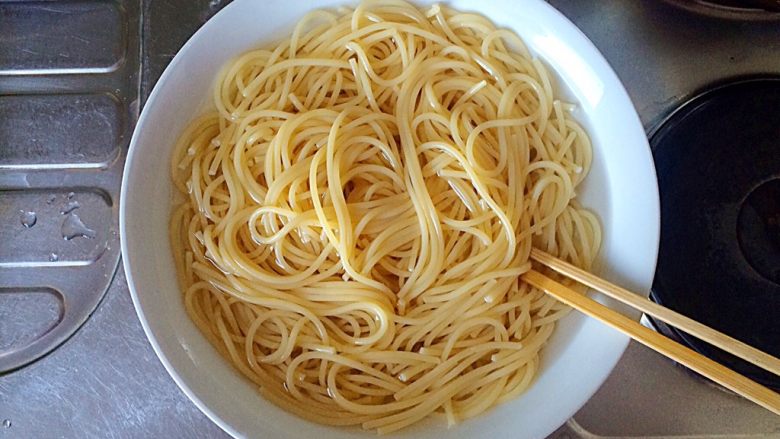 梅干菜炒意面,此时，意大利面也差不多煮好了。将面条捞入装有凉水的碗里。
