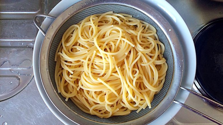 梅干菜炒意面,将过好凉水的意大利面倒入筛子中，沥去水分。
