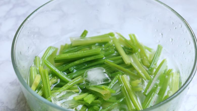 腰果仁炝芹菜,芹菜捞出放入冰水中浸泡，完全冷却后捞出沥水。