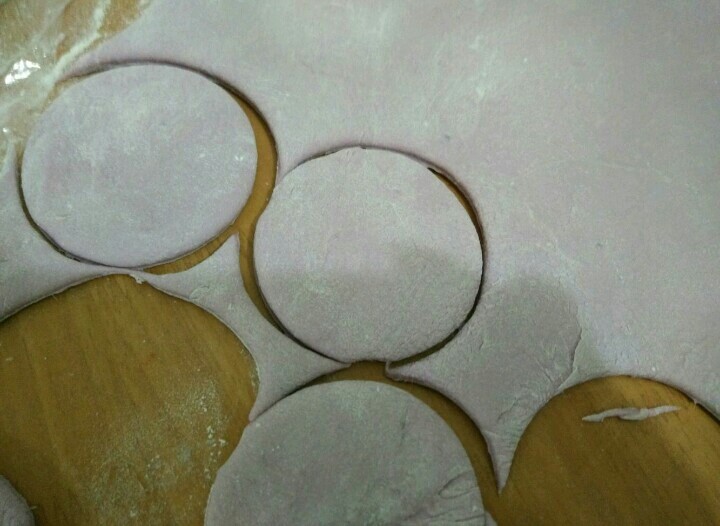 豌豆荚馒头,紫色面团充分排气后擀成片，厚大概有两个饺子皮叠起来的厚度。用饺子皮模具压出圆形。