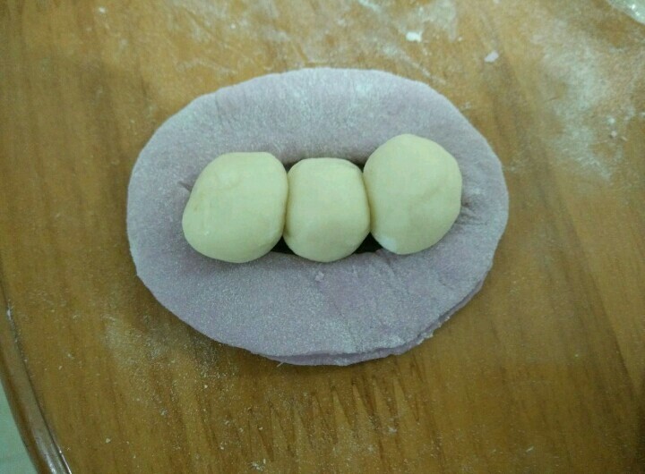 豌豆荚馒头,每个白色小圆抹点油，摆在紫色面团中间。