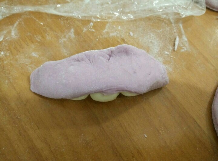 豌豆荚馒头,然后把紫色面团包起来，捏紧。