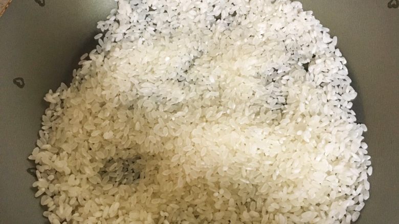 宝宝辅食6M➕：止泻焦米汤,将大米倒入锅中，再开小火翻炒