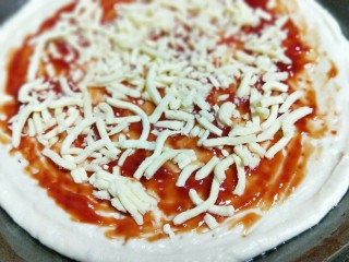 香甜玉米粒披萨,再披萨皮上均匀涂抹番茄酱，(可以根据自己喜欢换酱料，撒上一层马苏里拉芝士。