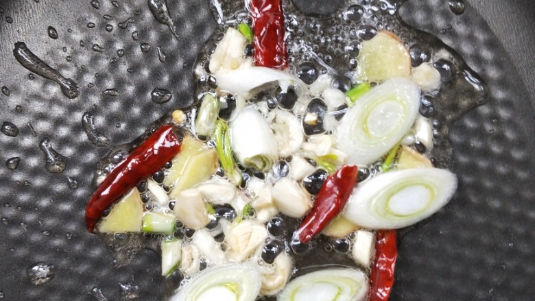 营养美味西蓝花炒腊肉,起油锅，放姜葱蒜和干辣椒。